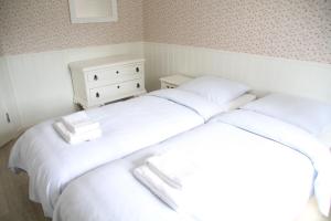 two beds in a small room with white sheets at BLÅBJERGGAARD - Hennebysvej 60 in Henne Strand