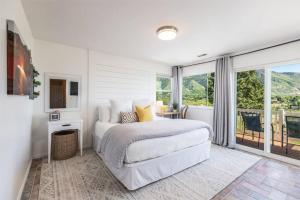 a white bedroom with a bed and a balcony at Hottub! Views! Basketball! Fireplaces! Mtn Trails in Sandy