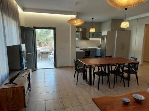 a kitchen and dining room with a table and chairs at VENTO villa neriana in Khainderianá
