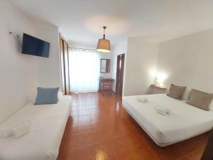 un soggiorno con due letti e un divano di Vicentina Rooms & Apartments - Duna Parque Resorts & Hotels a Vila Nova de Milfontes