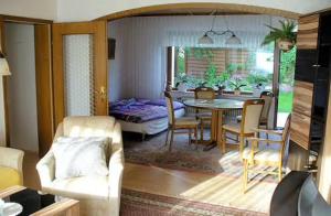 a dining room and living room with a table and chairs at Ferienwohnung Petryk in Weinheim