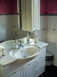 a bathroom with a white sink and a mirror at Ferienwohnung Petryk in Weinheim +6 photos
