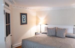 a bedroom with a bed with striped sheets and a window at Les Vergers de Saint Paul in Saint Paul de Vence