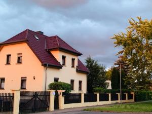 a white house with a red roof at Ferienwohnung Juttchen in Roßleben