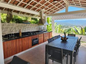 a kitchen with a table with chairs and a stove at LINDA CASA MEDITERRANEA in Ubatuba
