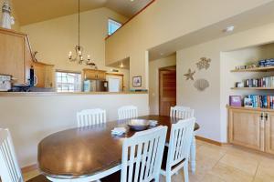 ロックアウェイ・ビーチにあるHoward's Lakehouse by the Seaの木製のテーブルと椅子のあるキッチンとダイニングルーム