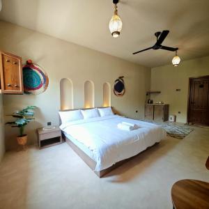 a bedroom with a bed and a ceiling fan at نزل عِطره Etra Inn in Nizwa