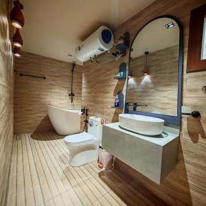 a bathroom with a tub and a sink and a toilet at نزل عِطره Etra Inn in Nizwa +43 photos
