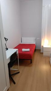 a small bedroom with a red bed and a desk at Sant Jordi Pisos - Consell de Cent in Barcelona