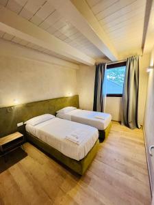 een slaapkamer met twee bedden en een raam bij La Collina sul Mare in Porto SantʼElpidio