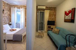 a bedroom with a bed and a couch in a room at Luna Apartment No3 in Ágios Rókkos
