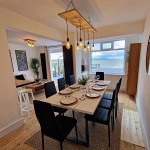 a dining room and living room with a table and chairs at Stunning Beachfront House, Herne Bay, Kent in Kent