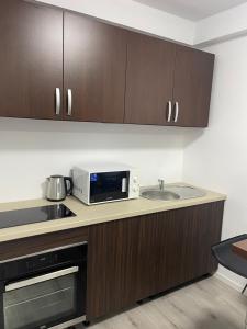 a kitchen with a microwave and a sink at Alexander Home in Techirghiol +8 photos