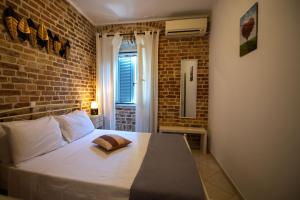 a bedroom with a bed with a brick wall at Luna Apartment No3 in Ágios Rókkos