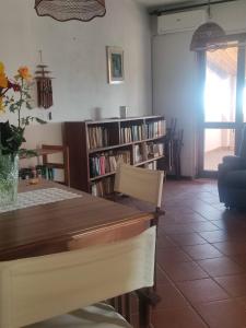 a dining room with a table and shelves of books at Villa degli Ulivi in Sciconi