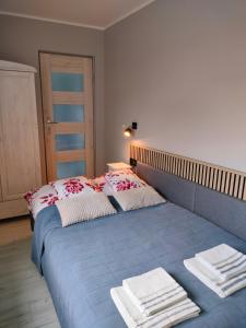 sypialnia z niebieskim łóżkiem i ręcznikami na nim w obiekcie APARTAMENT MILA w Świnoujściu
