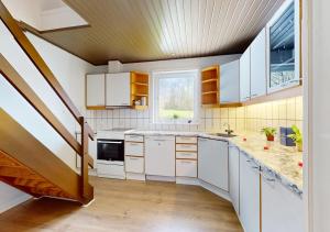 a kitchen with white cabinets and a staircase at Entire House in the City, 3 big bedroom with 4 Bed in Hobro