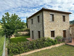 una vecchia casa in pietra con un giardino antistante di House in Tuscany - Casa La Scala a Gaiole in Chianti