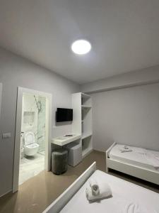 a room with a bed and a bathroom with a television at Joal Rooms in Sarandë