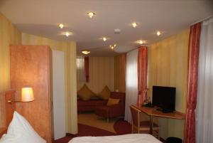 a hotel room with a bed and a living room at Hotel Altes Rathaus in Ostfildern