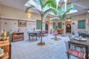 un soggiorno con due palme al centro di Riad Inaka a Marrakech