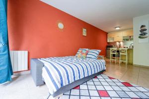ein Schlafzimmer mit einem Bett mit einer orangefarbenen Wand in der Unterkunft Montevrain disney 10mn Parking privé in Montévrain