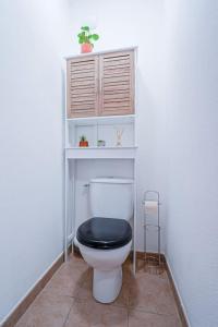ein Badezimmer mit einem WC und einem schwarzen Sitz in der Unterkunft Montevrain disney 10mn Parking privé in Montévrain