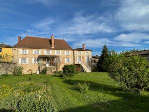 a large brick house with a grass yard at Le Logis D'Azé in Azé