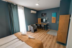 a room with a bed and a table in a room at Pensiunea Urban Point in Sfântu-Gheorghe