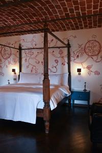 een slaapkamer met een bed met rood bloemenbehang bij Relais Conac 1888 - Luxury B&B - Adults Only in Castelnuovo Don Bosco +64 foto's