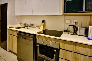 une cuisine avec une cuisinière et un micro-ondes dans l'établissement Tranquility meets serenity, à Ballito