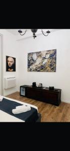 a bedroom with two beds and paintings on the wall at Sa Costixedda Rooms in Cagliari