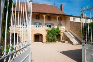an open gate to a large house with stairs at Le Logis D'Azé in Azé