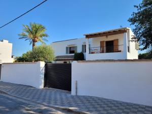 a white house with a gate and a fence at La Casa del Sol in La Eliana