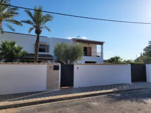 a house with white gates and a palm tree at La Casa del Sol in La Eliana +21 photos