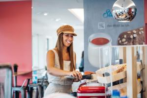 a woman is smiling while standing behind a counter at Stay Hotel Porto Centro Trindade in Porto