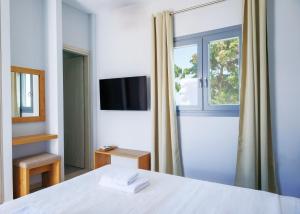 a bedroom with a white bed and a window at Blue Sea Paros Aegean Horizon in Drios +57 photos