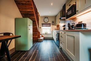 a kitchen with a green refrigerator and a wooden floor at ThePiggery No 14 in Haxey