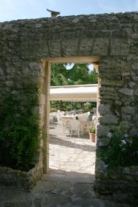 an archway in a stone wall with tables and chairs at Les Geraniums in Le Barroux