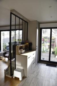 アニエール・シュル・セーヌにあるLe Clos Ménilの白いキャビネットと大きな窓のあるキッチン