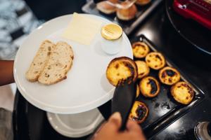 a person cutting a plate of food with a knife at Stay Hotel Porto Centro Trindade in Porto