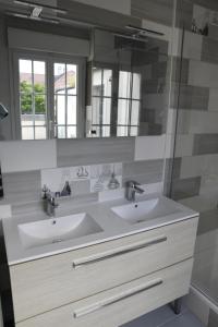 アニエール・シュル・セーヌにあるLe Clos Ménilの洗面台が2つと鏡があるバスルーム