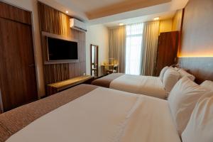 a hotel room with two beds and a flat screen tv at Brizo Salta in Salta