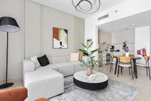 uma sala de estar com um sofá branco e uma mesa em Silkhaus Luxury 1BDR with easy access to the Canal em Abu Dhabi