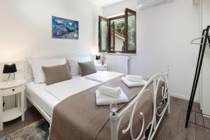 a white bed in a white room with a bed frame at Apartman Kalinda in Rijeka