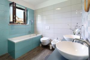 a bathroom with a tub and a toilet and a sink at Apartman Kalinda in Rijeka +32 photos