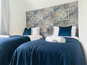 two beds in a room with blue and white at Home Away Luxury Living - Horley in Horley