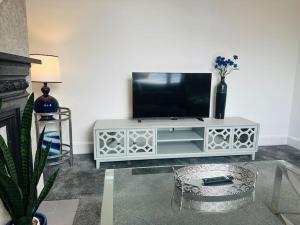 a living room with a television on a white entertainment center at Home Away Luxury Living - Horley in Horley