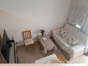 a small bedroom with a bed and a chair at Casa Teo. in Santa Pola