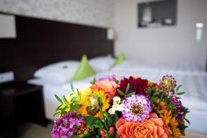 
a bouquet of flowers in a vase on a bed at President Hotel in Bonn
